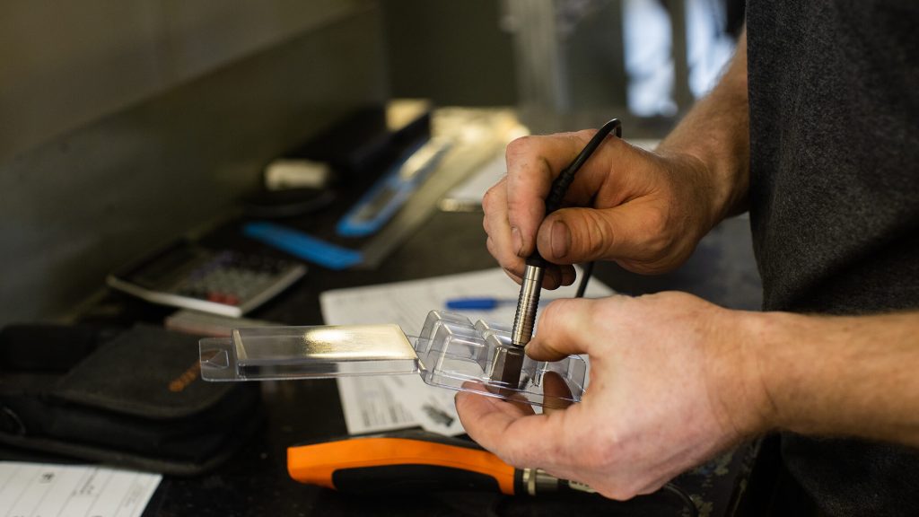 man's hands measuring a package prototype