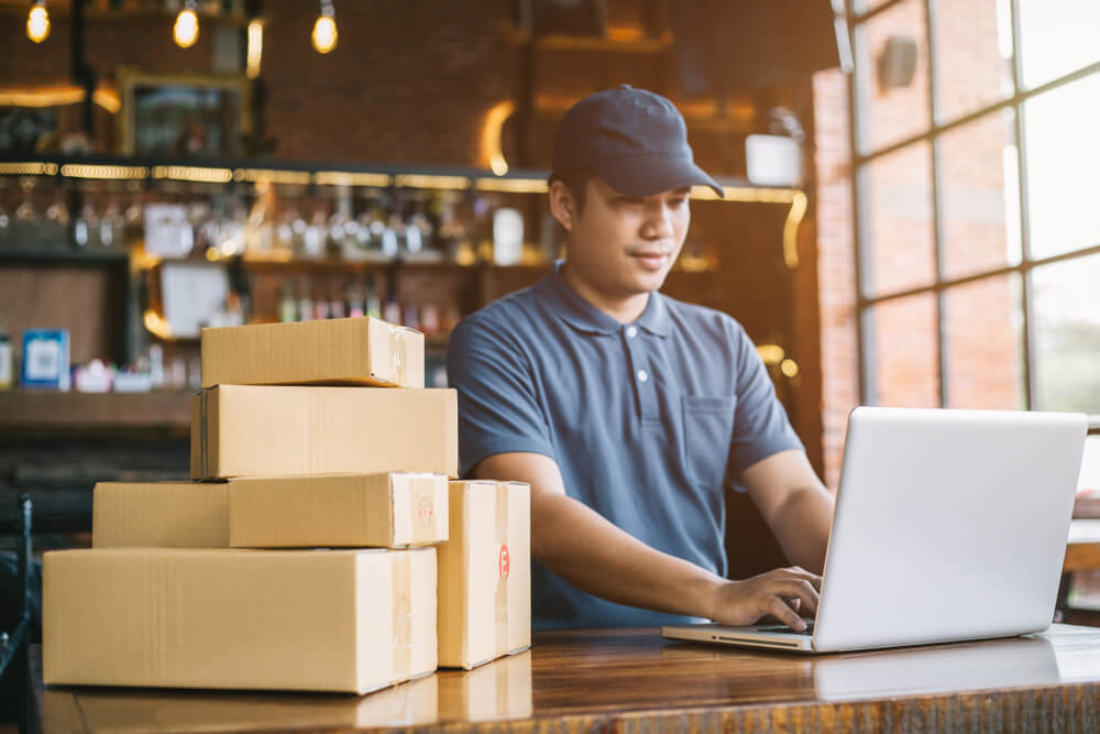 ecommerce business packaging on laptop as owner works from desk